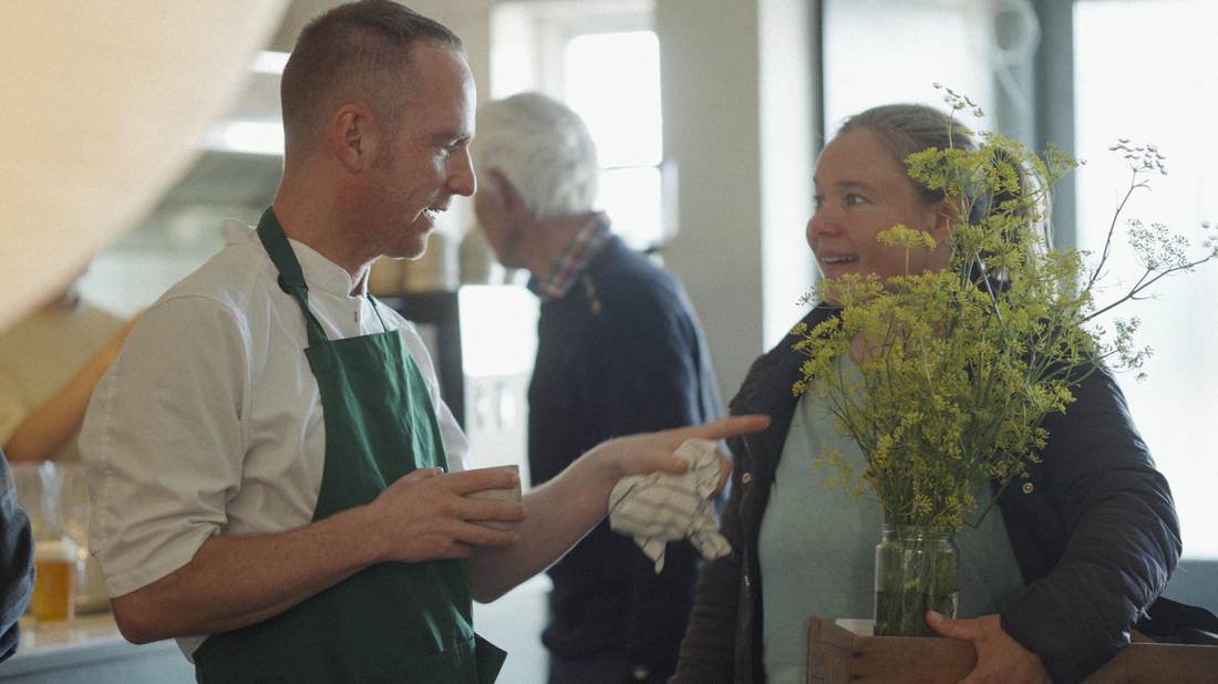 Kok og kollega med friske urter i køkkenet på Beghuset