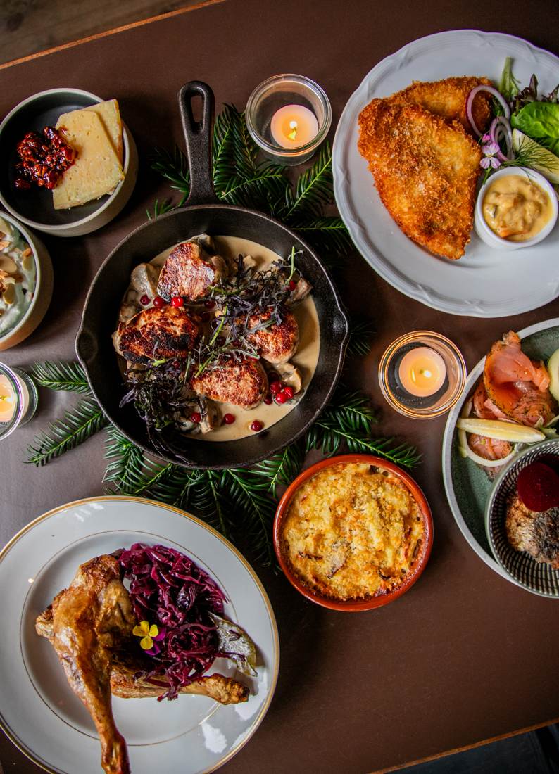Beghusets julebord set ovenfra med and, frikadeller, gratin og røget laks